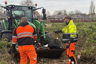 Two council workers using a tractor to help tidy up