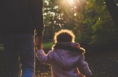 A child and adult hold hands